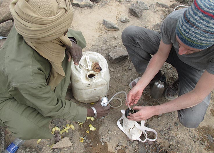 Das Tibesti Gebirge, Expeditionsteilnehmer filtern Trinkwasser, Explore Chad